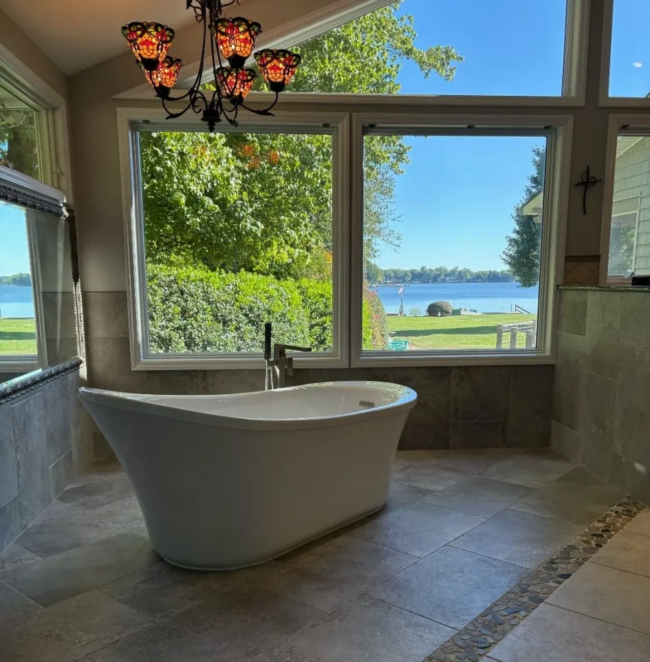 Completed bathroom with freestanding bathtub and lake view